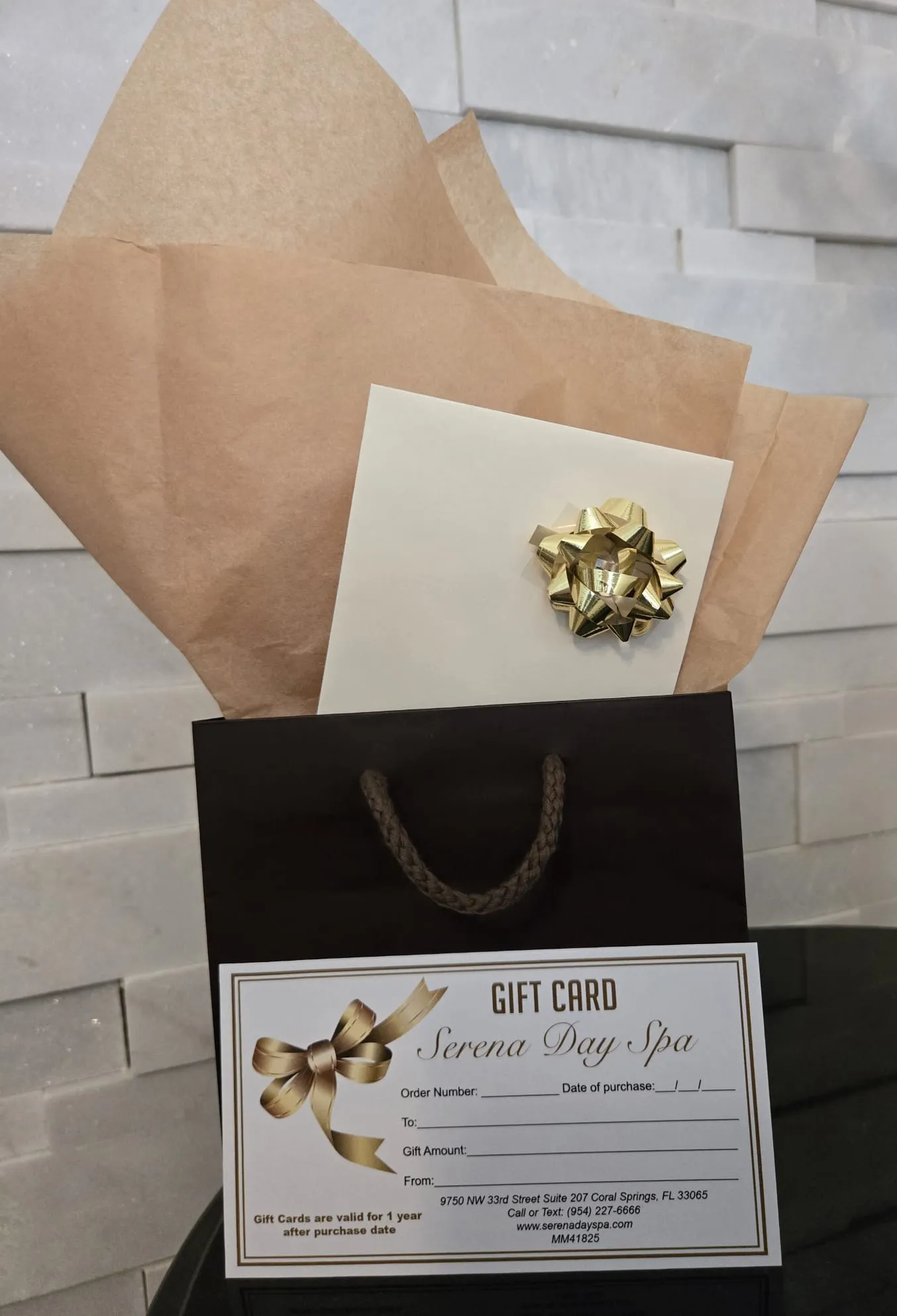 Serena Day Spa gift card in a gift bag with gold bow